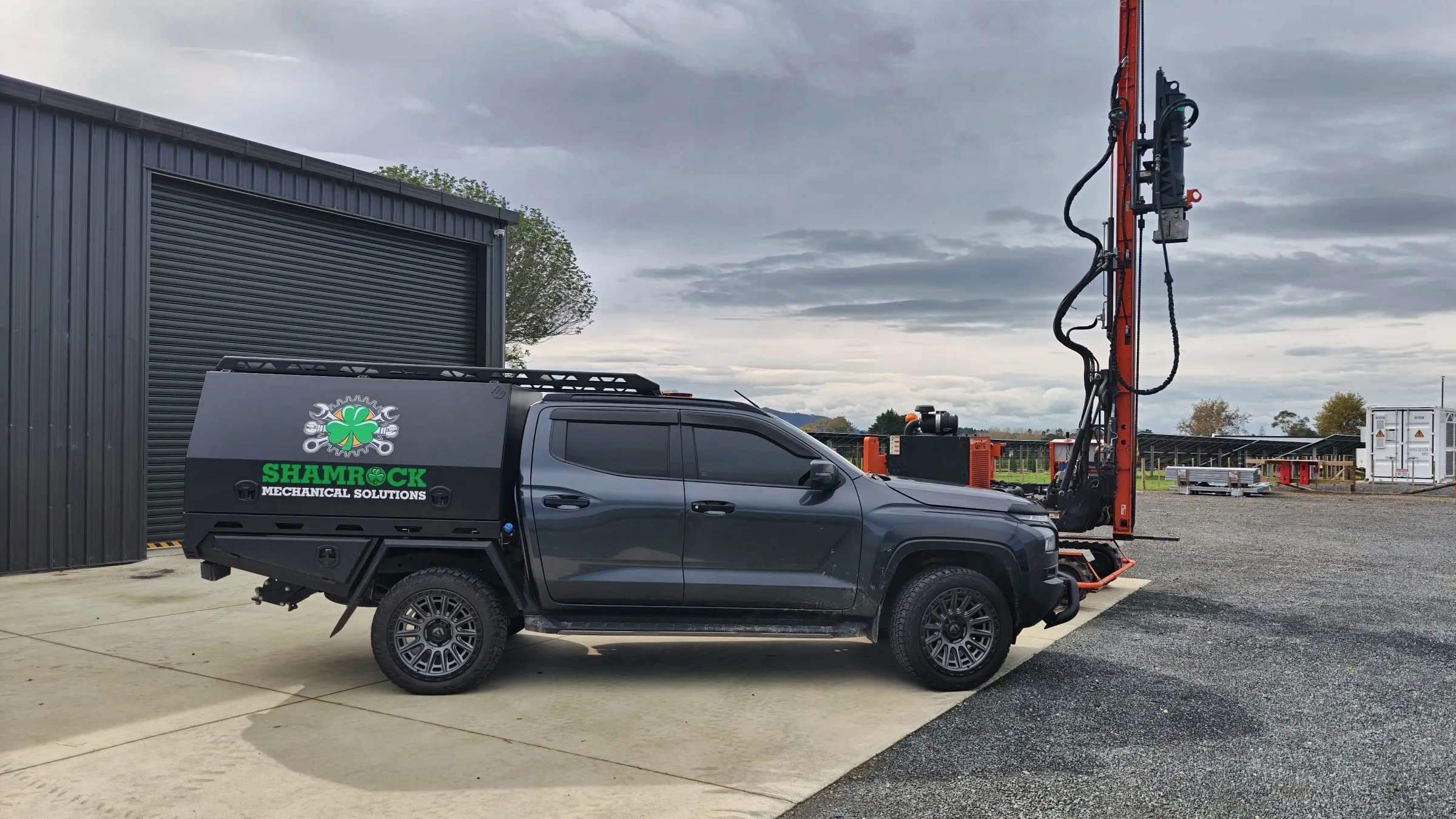 Shamrock service truck beside a red drilling mast