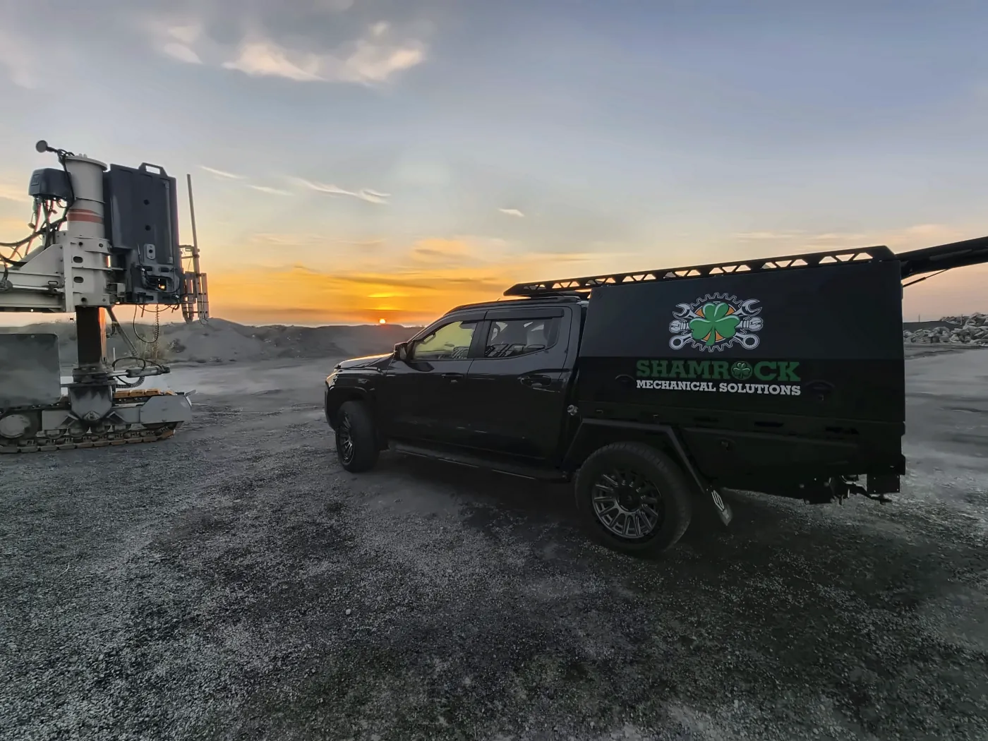 Service truck at last light next to a drilling rig