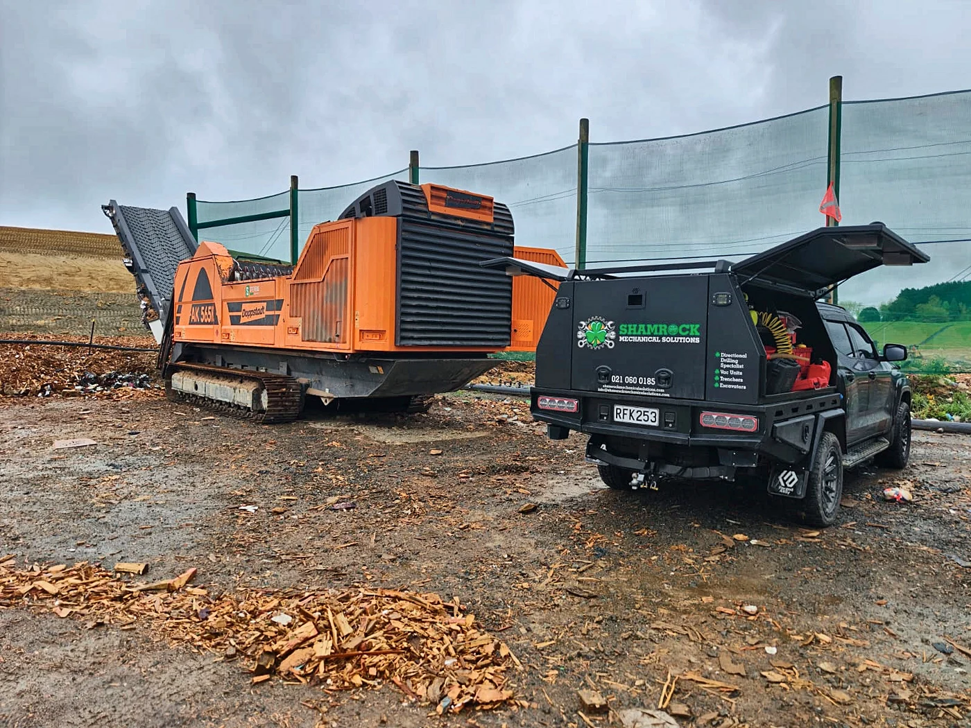 Shamrock service truck beside a Doppstadt wood shredder on a green-waste site